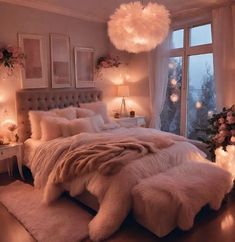 a bedroom decorated in pink and white with lights on the windowsill, fur rugs and bedding