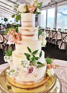 a three tiered wedding cake with flowers on top