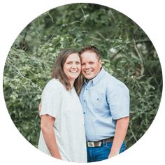 a man and woman standing next to each other in front of trees