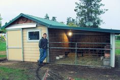 a man standing in front of a shed next to a yard with animals on it