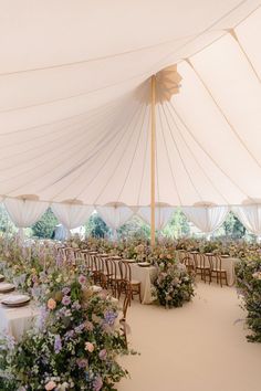 tables and chairs are set up under a large tent