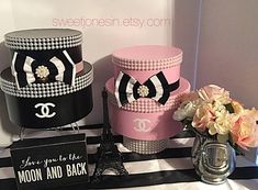 three cakes decorated with pearls and bows on top of a black and white table cloth