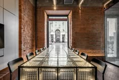 an empty conference room with brick walls and glass tables set up for people to sit at