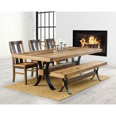 a dining room table with benches and a fire place