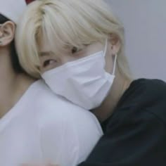 two people with masks on their faces, one is hugging the other's shoulder