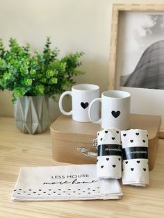 three coffee mugs sitting on top of a wooden table next to two napkins