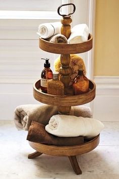 a three tiered shelf with towels and other items on it