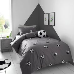 a soccer themed bedroom with grey walls and white flooring, along with black and white decor