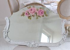 a mirror sitting on top of a white table next to a dining room set up