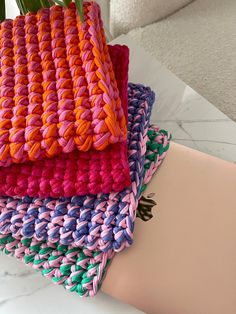 three crocheted placemats stacked on top of each other, one pink and one blue