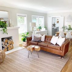 a living room filled with furniture and a fire place next to a fireplace covered in plants