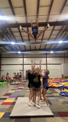 two girls are jumping in the air on a trampoline course while others watch