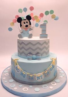 a mickey mouse 1st birthday cake with balloons