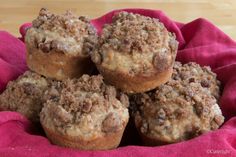 a pile of muffins sitting on top of a red cloth