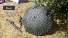 an open umbrella sitting on the ground next to a tree and other items that have been placed around it