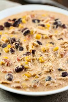 a white bowl filled with black beans, corn and cheese soup on top of a table