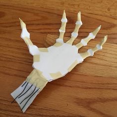 a hand made out of paper sitting on top of a wooden table