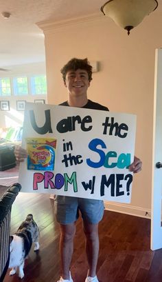 a man holding up a sign that says, you are the in the sea prom with me?