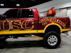 a red and yellow truck parked in a garage next to a helmet on top of it