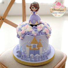 a purple and white cake sitting on top of a wooden chair