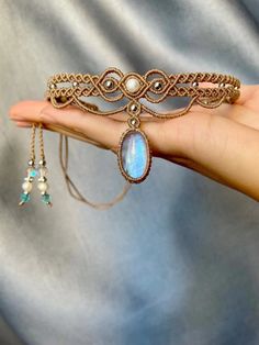 a hand holding a piece of jewelry in it's palm, with an opulent stone