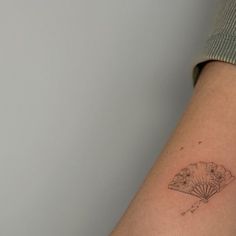 a woman's arm with a small tattoo on the left side of her arm