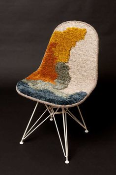 a chair made out of yarn with metal legs and a colorful seat cushion on top of it