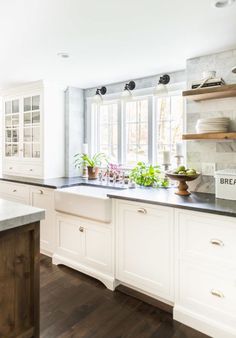 a kitchen with white cabinets and black counter tops is seen in this image from the front