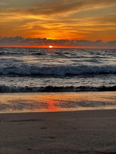 the sun is setting over the ocean with waves