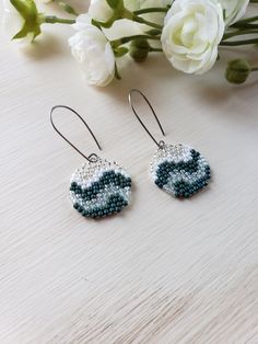 the beaded earrings are on display next to flowers