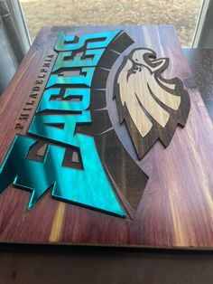 a wooden sign with the words spirit and an eagle on it sitting on a table in front of a window