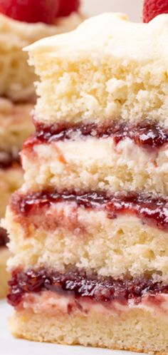 a piece of cake with raspberry filling on top and another slice in the background