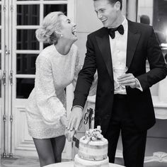 a man in a tuxedo standing next to a woman with a cake