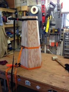 a workbench in a garage with tools and materials on the table, including a large piece of wood