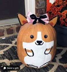 a pumpkin with a corgi on it sitting in front of a door