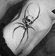 a black and white photo of a woman's stomach with a spider tattoo on it