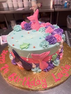 a birthday cake decorated with pink, blue and purple decorations