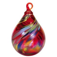 a colorful glass ornament hanging on a white background