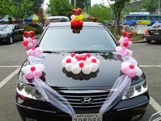 a car decorated with balloons and bows