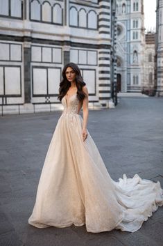 a woman standing in front of a large building wearing a dress with flowers on it