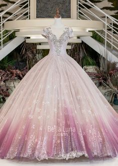 a pink and white ball gown on display at the bridal show in front of stairs