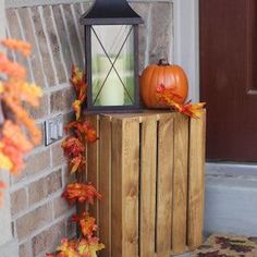 the front door is decorated with fall leaves and an old fashioned lantern on it's stand