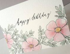 a happy birthday card with pink flowers and green leaves on the front, written in black ink