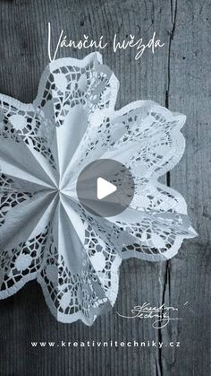 the video is showing how to make an origami flower with lace on it