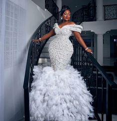 a woman in a white gown standing on stairs