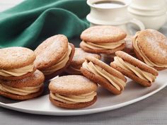 cookies with frosting on a plate next to a cup of coffee