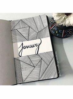 a notebook with the word january written on it next to a flower