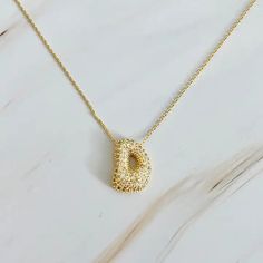 Elevate your jewelry collection with our Crystal Bubble Initial Necklace. Adorned with sparkling crystals, this versatile piece adds a touch of elegance and personalization to any outfit. 16" with a 2" extender, made of 18k gold plated brass, lead, and nickel-free. Make a statement, wear it alone or layer it with other accessories. Gold Plated Necklaces With Sparkling Stones For Anniversary, Anniversary Gold Plated Necklaces With Sparkling Stones, Yellow Gold Plated Necklaces With Pave Setting, Yellow Gold Plated Necklace With Pave Setting, Yellow Gold-plated Necklace With Pave Setting, Gold Plated Necklaces With Pave Setting For Gift, Gold Plated Rhinestone Necklace With Adjustable Chain, Gold Necklaces With Pave Setting In Sterling Silver, Gold Cubic Zirconia Necklace With Pave Setting