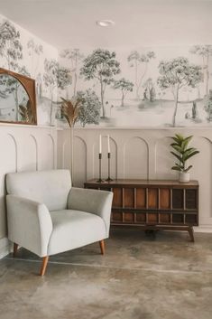 a living room with a chair, mirror and wallpaper on the walls in it