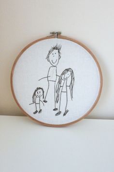 a drawing of a man and woman with a child in their arms on a white surface